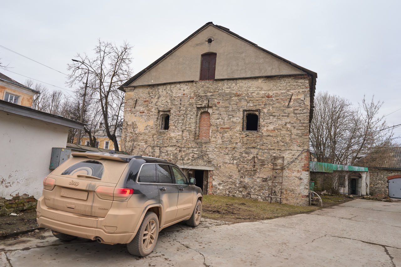 Полевая съёмка фасада Палат Русиновых в Пскове с автомобилем на переднем плане